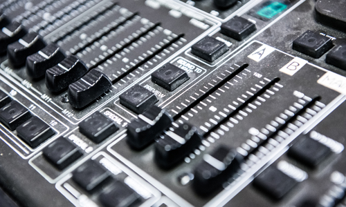 A close up photograph of a soundboard used for audio production