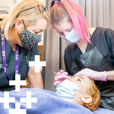 Photo of beauty therapy student practicing on a fellow student. Next to the student is her lecturer